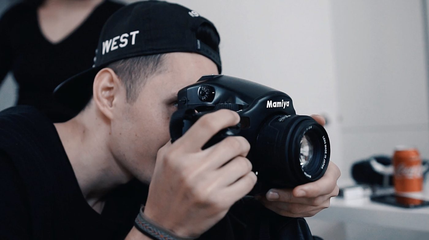 A photographer looking through a medium-format camera